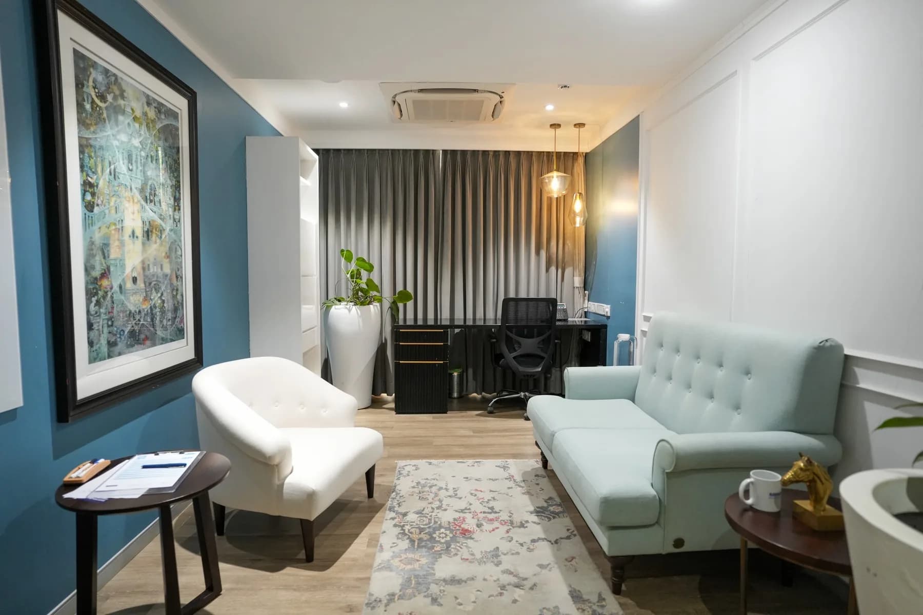 A consulting room with a blue accent wall and soft armchair